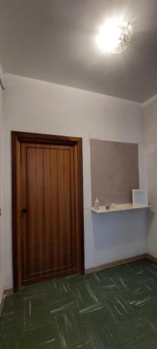 a room with a wooden door and a shelf at Ti Racconto di un Sogno Rooms - Cielo & Terra in Chianciano Terme