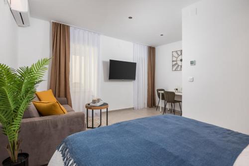 a bedroom with a bed and a couch and a tv at Apartment Salita Calvario in Rijeka