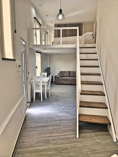 Pokój z łóżkiem na podwyższeniu i schodami w obiekcie Suloti House Lungomare we Wlorze