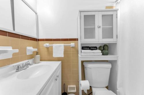 a bathroom with a white toilet and a sink at Maple Heights Getaway in Maple Heights