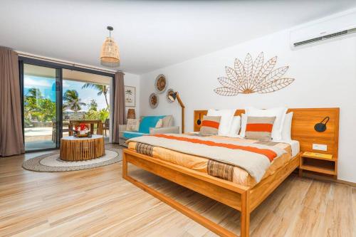 um quarto com uma cama grande e uma janela grande em Alamanda Studio n°6 / Beachfront Res - Orient Bay em Orient Bay