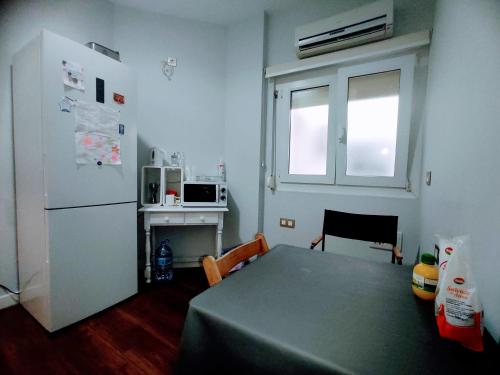 een kleine keuken met een tafel en een koelkast bij Carretónas room in Granada