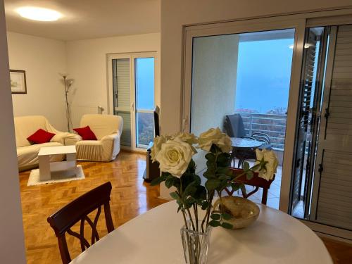 a living room with a vase of flowers on a table at Apartment Tina in Rijeka