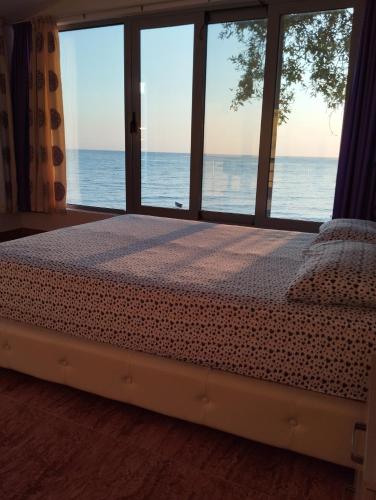 a bedroom with a bed with a view of the ocean at Summer Beach House in Ulcinj
