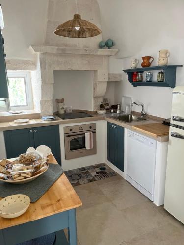 una cocina con fregadero y estufa horno superior en Trullo in vigna, en Cisternino