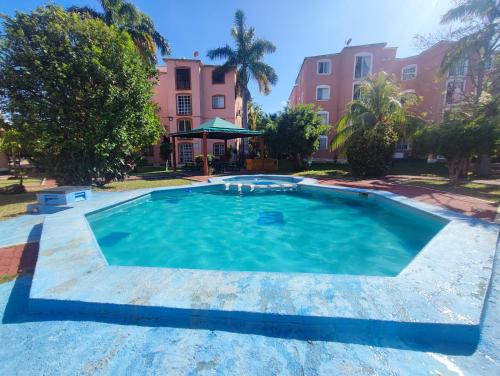 a swimming pool in a yard with a building at Cancun Property 6 personas in Cancún