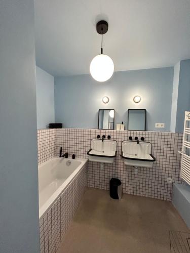 une salle de bain avec deux lavabos et une baignoire dans l'établissement Maison avec patio et spa centre ville, à Narbonne