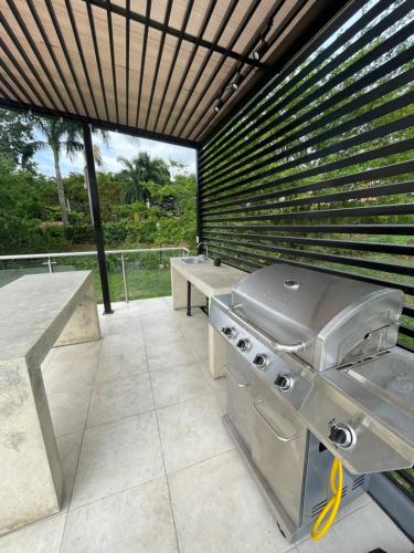 a barbecue grill on a patio with a bench at Apartaestudio de lujo en Cali in Cali