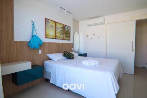 a bedroom with a white bed with towels on it at Cobertura de Luxo em Resort Beira Mar - Qavi in Búzios