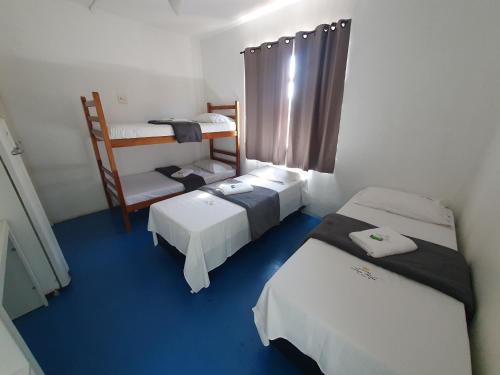 a room with two beds and a bunk bed at Hospedaria Dom Pedro - 500m do metrô in Sao Paulo