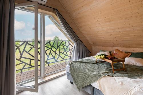 a bedroom with a bed and a large window at Domki Sarbinowo Elizjum in Sarbinowo