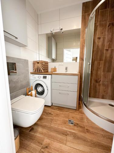 a bathroom with a toilet and a washing machine at LuxFlats Apartament Boho in Jastrzębia Góra