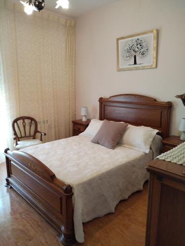 a bedroom with a large bed with a wooden frame at Casa López in San Mamede de Carnota