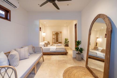 Sala de estar con 2 camas y espejo en Cozy Up Villa Sanur en Sanur