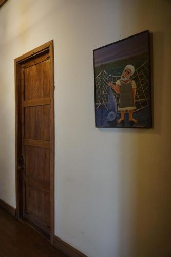 a painting of a girl on a wall next to a door at Old Sighnaghi in Sighnaghi