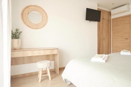 a bedroom with a bed and a mirror and a chair at CASA DO LÍRIO - Alojamento Local in Fátima