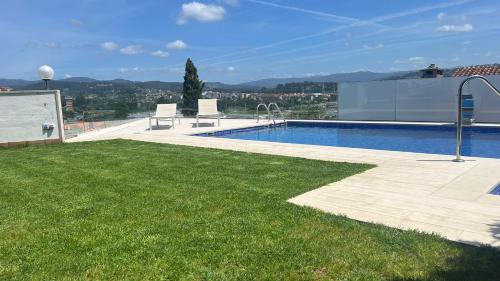 een zwembad bovenop een gebouw met een groen gazon bij Mirador Relax La Caeira en Pontevedra in Poio