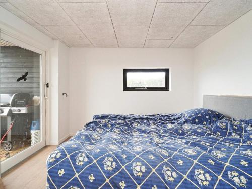 Un dormitorio con una cama azul y una ventana en Holiday home Slagelse XXXVIII, en Slagelse
