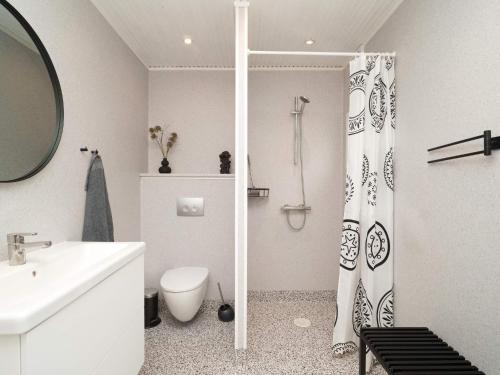 a white bathroom with a toilet and a shower curtain at 6 person holiday home in Højby-By Traum in Højby