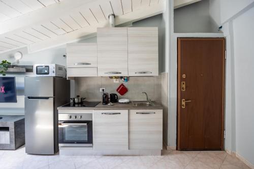 a kitchen with white cabinets and a stainless steel refrigerator at Free Parking Tiny House Wifi Netflix 15 Minuti dal Duomo in Milan