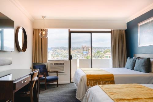Habitación de hotel con 2 camas y ventana en Corona Hotel & Spa en Ensenada