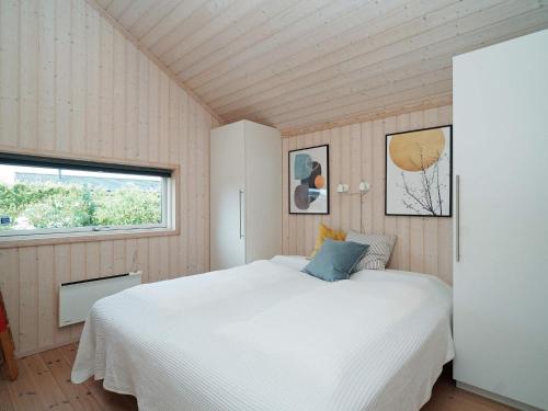 um quarto com uma cama branca e uma janela em Holiday home Slagelse XLVII em Slagelse