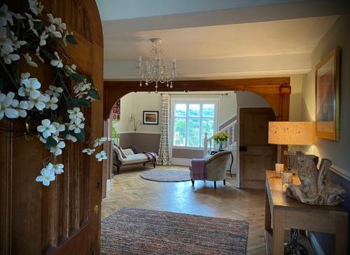 a living room with a chandelier and a living room with a couch at The Old Rectory with Valley View in Stockton on Teme