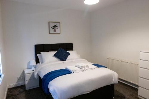 a bedroom with a large white bed with blue accents at Gillingham Two bedroom house with garden and free parking in Gillingham