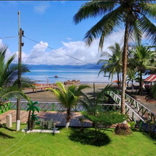 vistas a una playa con palmeras y al océano en Cabañas las perlas en Bahía Solano