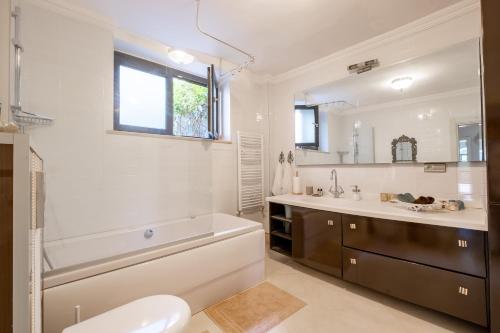a bathroom with a tub and a sink and a toilet at Homie Suites - 3br villa w pool in Heybeliada in Adalar