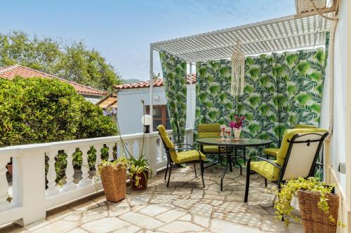 a patio with a table and chairs on a balcony at Panagou Studios in Skopelos Town