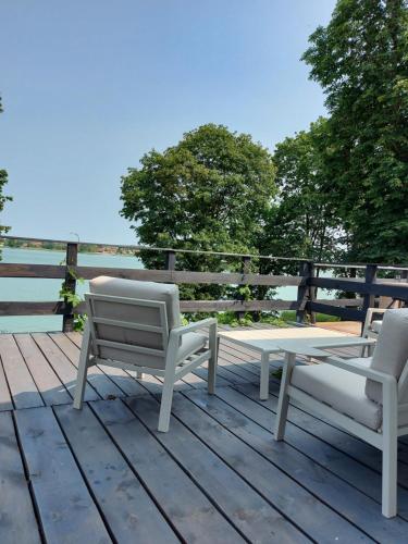 two chairs and a table on a wooden deck at Pokoje i apartamenty MatDar in Mikołajki