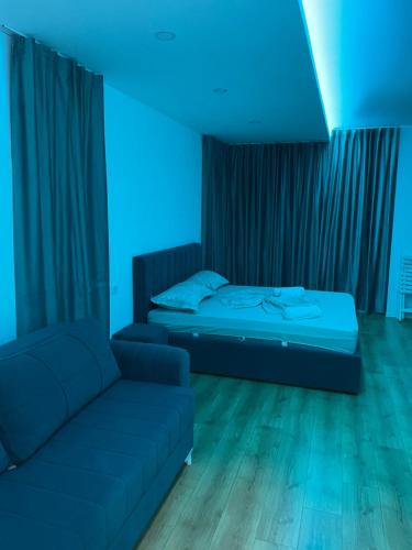 a room with a couch and a bed with blue lights at Suite Rana Hedhun in Shëngjin