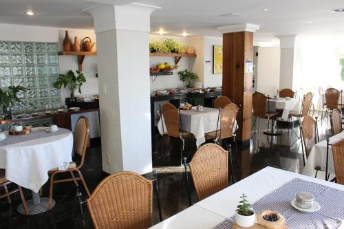 un comedor con mesas y sillas en un restaurante en Novo Hamburgo Business Hotel, en Novo Hamburgo