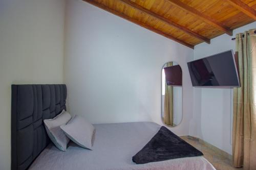 um quarto com uma cama e uma televisão de ecrã plano em Apartamento a 3 min del Hospital Pablo tobón uribe em Medellín