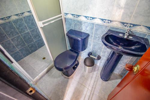 uma casa de banho com um WC azul e uma lata de lixo em Apartamento a 3 min del Hospital Pablo tobón uribe em Medellín