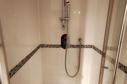 um chuveiro com um telefone na casa de banho em Stylish flat in London with free parking em Londres