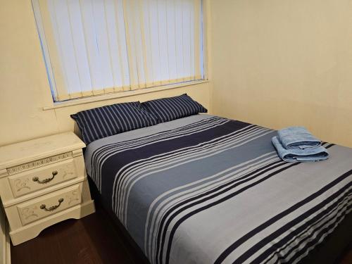 1 dormitorio con 1 cama, mesita de noche y ventana en Axel room 2 en Mánchester