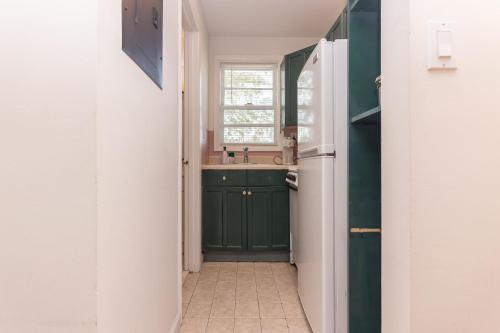 a kitchen with green cabinets and a sink at Fort Lauderdale Studio - 5 minutes walking to Las Olas Beach in Fort Lauderdale