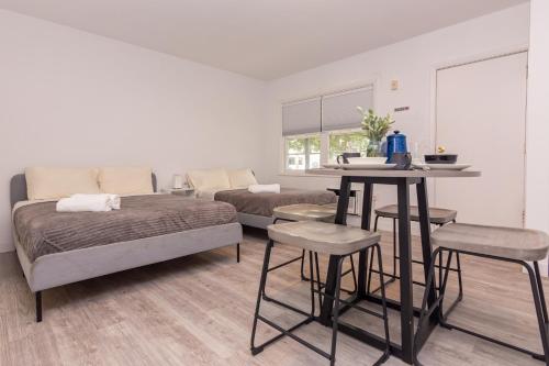 a bedroom with two beds and a table and chairs at Studio Las Olas Beach - Fort Lauderdale - 5 minutes walk to beach in Fort Lauderdale