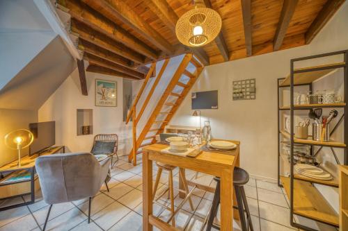 une cuisine et une salle à manger avec une table et des chaises en bois dans l'établissement Le Petit Jaurès - Gare / Tram, à Grenoble