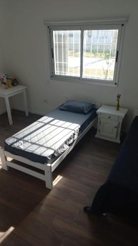 a bed in a room with a window at Descanso en Las Acequias in Roldán