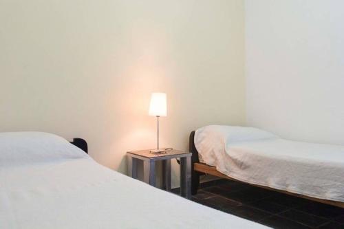 a room with two beds and a lamp on a table at Del Fundador in San Luis