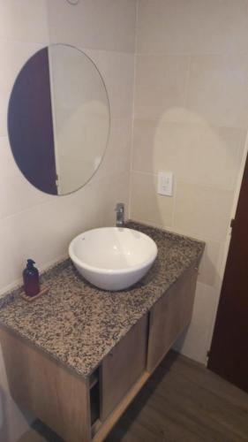 a bathroom with a white sink and a mirror at Descanso en Las Acequias in Roldán