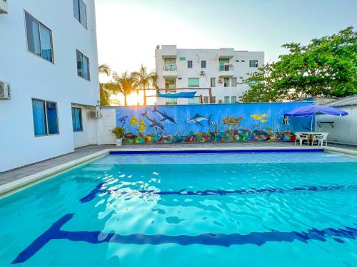 a swimming pool in front of a building with a mural of fish at APARTAMENTO CERCA AL MAR EN TOLÚ in San Silvestre