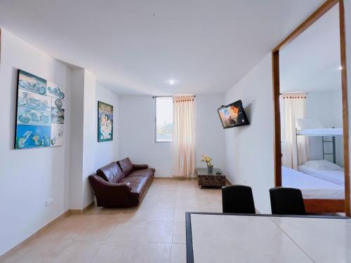 a living room with a couch and a bed at APARTAMENTO CERCA AL MAR EN TOLÚ in San Silvestre