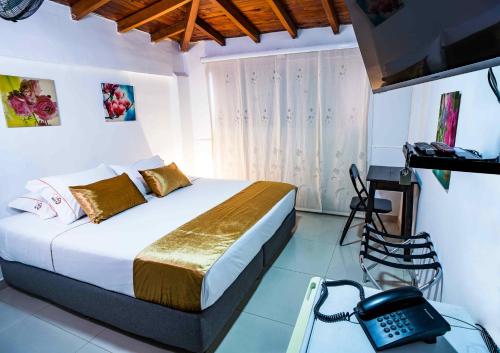 a bedroom with a bed and a telephone in it at Hotel Casa 10 in Medellín