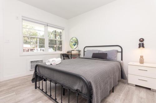 a white bedroom with a bed and a window at Studio Las Olas - Fort Lauderdale - 5 minutes walk to beach in Fort Lauderdale