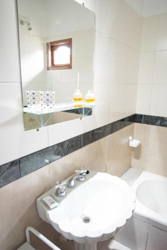 a white bathroom with a sink and a mirror at 615 in Ushuaia
