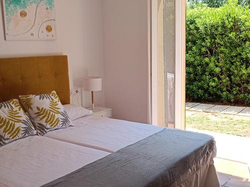 1 dormitorio con 1 cama y puerta que da a un jardín en "PARAÍSO 14" Espectacular casa con terrazas, piscina y vistas al mar, en Son Xoriguer